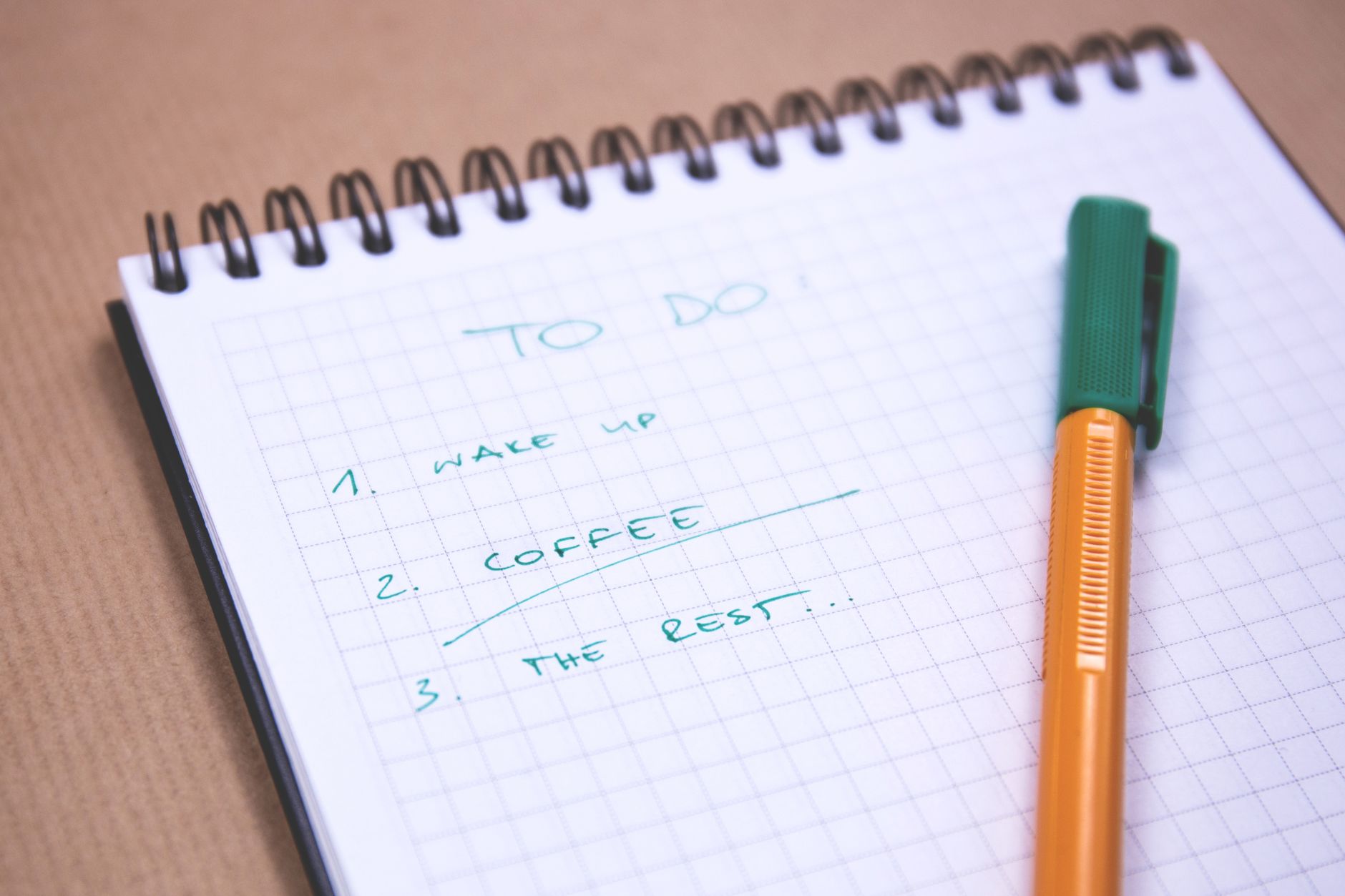 Handwritten to-do list on graph paper notebook with pen. Ideal for organizing tasks.